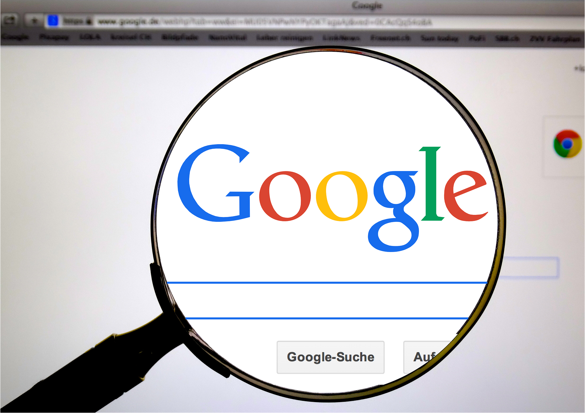 A magnifying glass is held up to the Google search engine homepage, enlarging the Google logo. The browser tab and address bar are visible at the top, while the search bar and buttons below the logo are slightly blurred. The image highlights the concept of searching and navigating the web, with a focus on Google's prominence as a search engine.